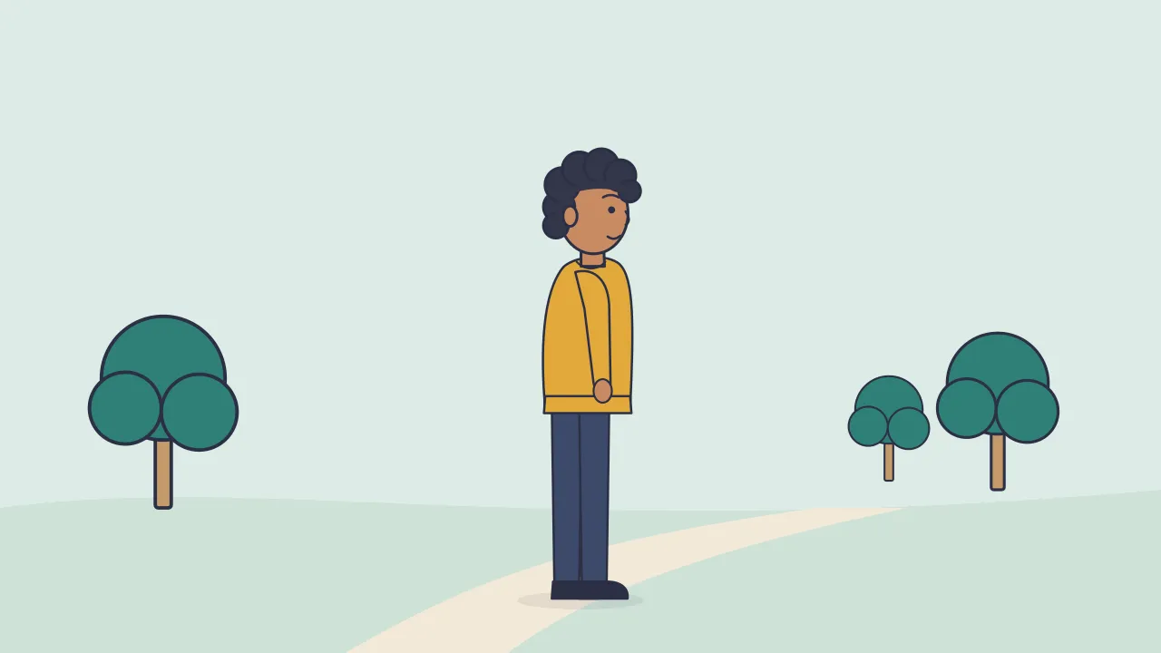 A person standing on a path in a park between trees