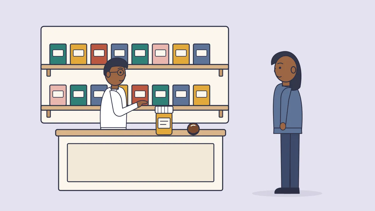 A pharmacist behind a counter points to a small supplement bottle while an adult customer listens