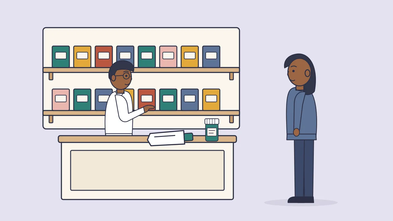 A pharmacist behind a counter talks with an adult customer, with shelves of unlabeled boxes and bottles behind them